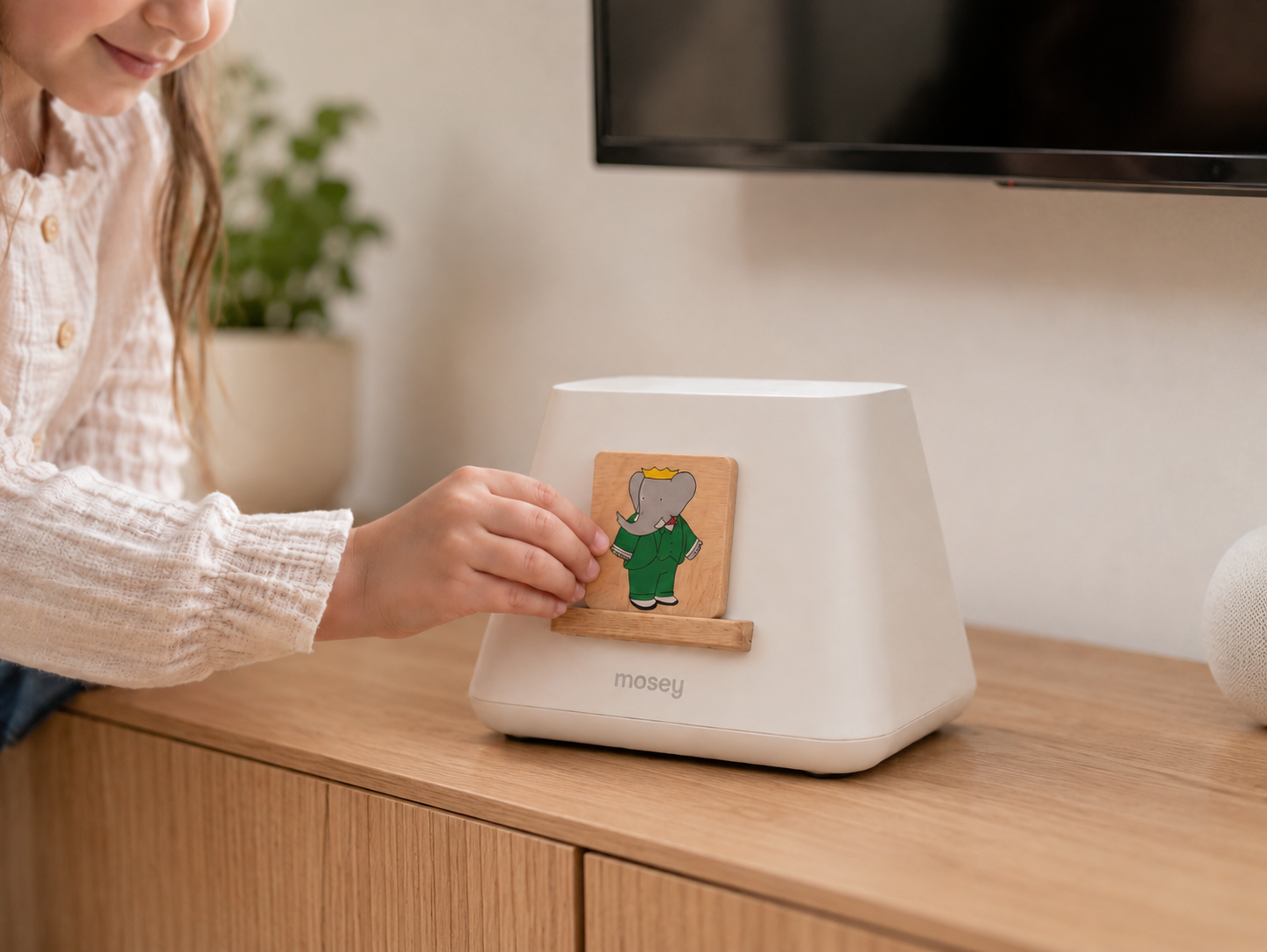 A child placing a tile onto the Mosey console to start their show